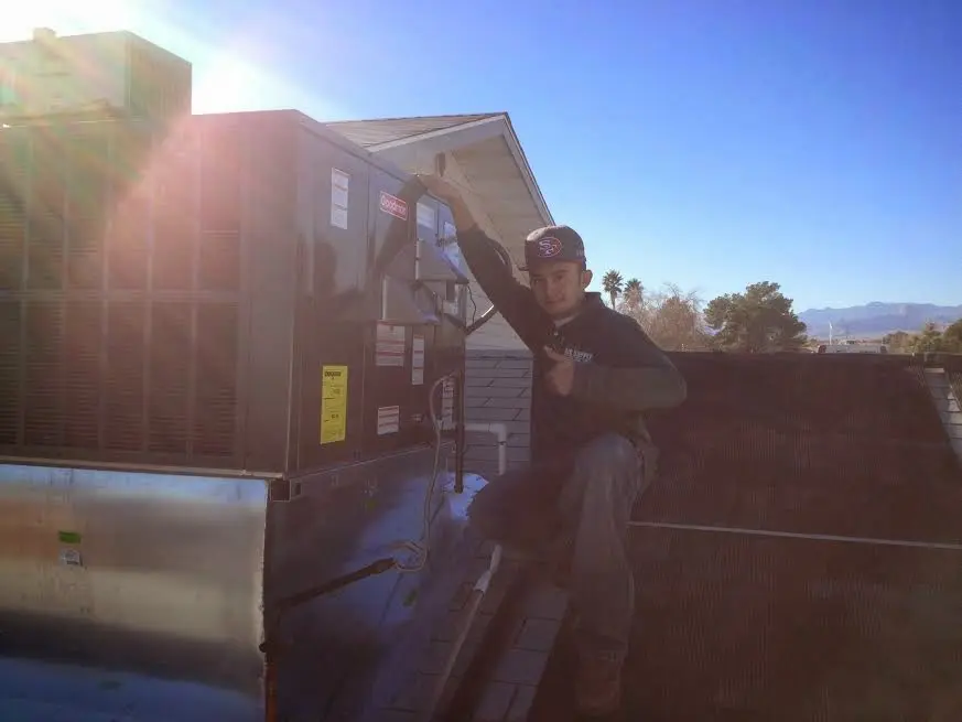 HVAC technician performing Heat Pump Repair on a rooftop unit in Garden City